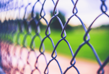 Chain link fence bordering a baseball field