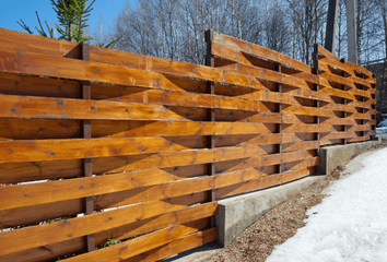 Thick wooden fence with modern curved horizontal slats